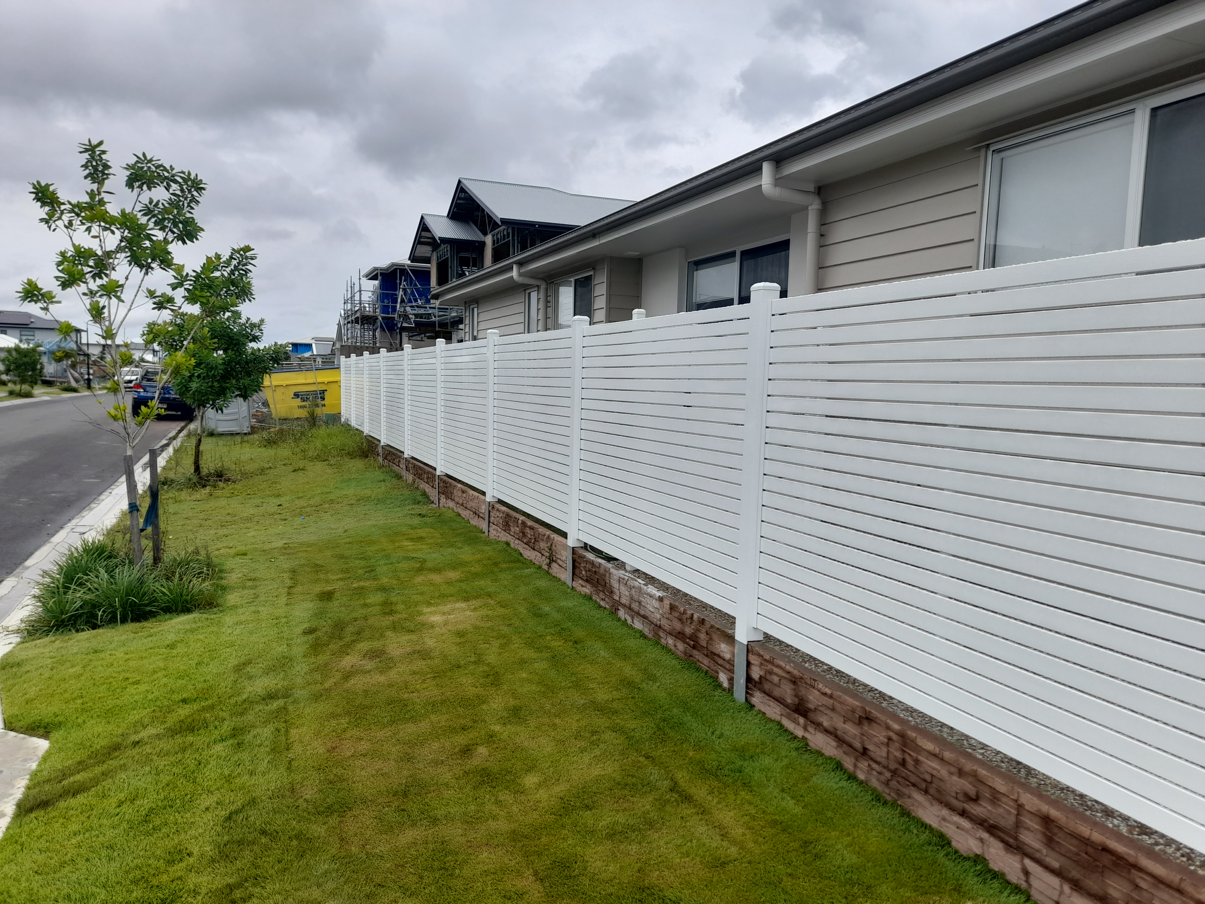 Modern white aluminium picket fencing running along a Moreton Bay front yard - Gateflex, Caboolture